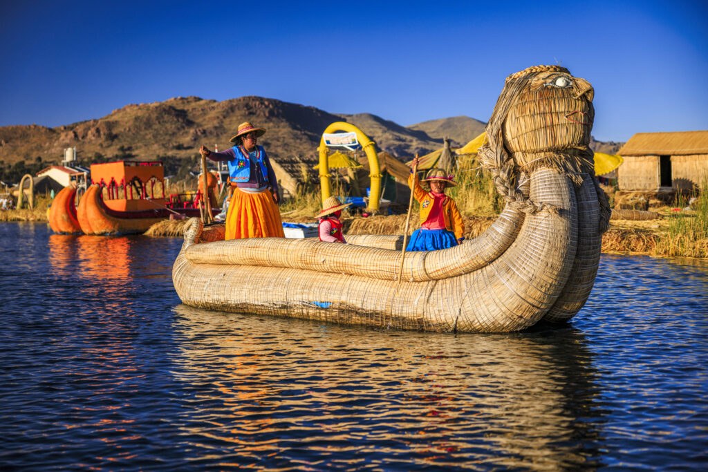 Peruvian young woman sailing between Uros floating islands, Lake Titicaca